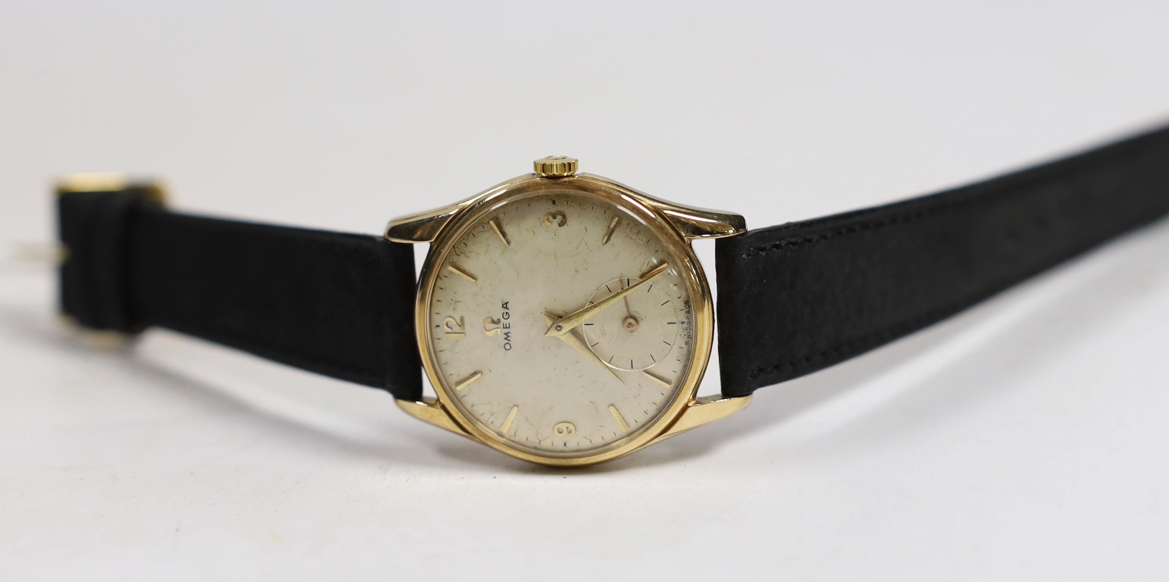 A gentleman's 9ct gold Omega manual wind wrist watch, with case back inscription, on associated leather strap, case diameter 34mm.